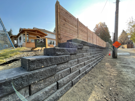 Sienna stone retaining wall and wood fence.